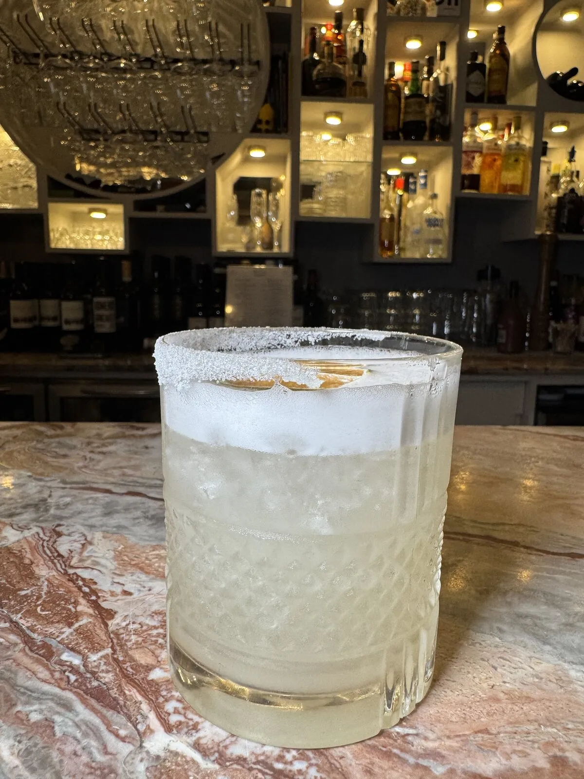 Cocktail with a salted rim on the Rex Cross marble bar